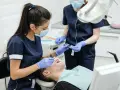 Dentystka wykonuje zabieg. Dowiedz się, jaka jest usuwanie zębów pod narkozą cena i jak przebiega.