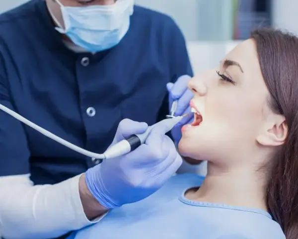 Dentysta wykonuje zabieg, a pacjentka zastanawia się, ile kosztuje znieczulenie u dentysty.